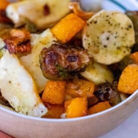 A bowl brimming with deliciously roasted Brussels sprouts, fragrant butternut squash, and perfectly seasoned parsnips.