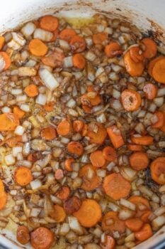 Chopped onions and sliced carrots sautéing in a pot with a sprinkle of paprika create the perfect aromatic base for braised country style ribs.