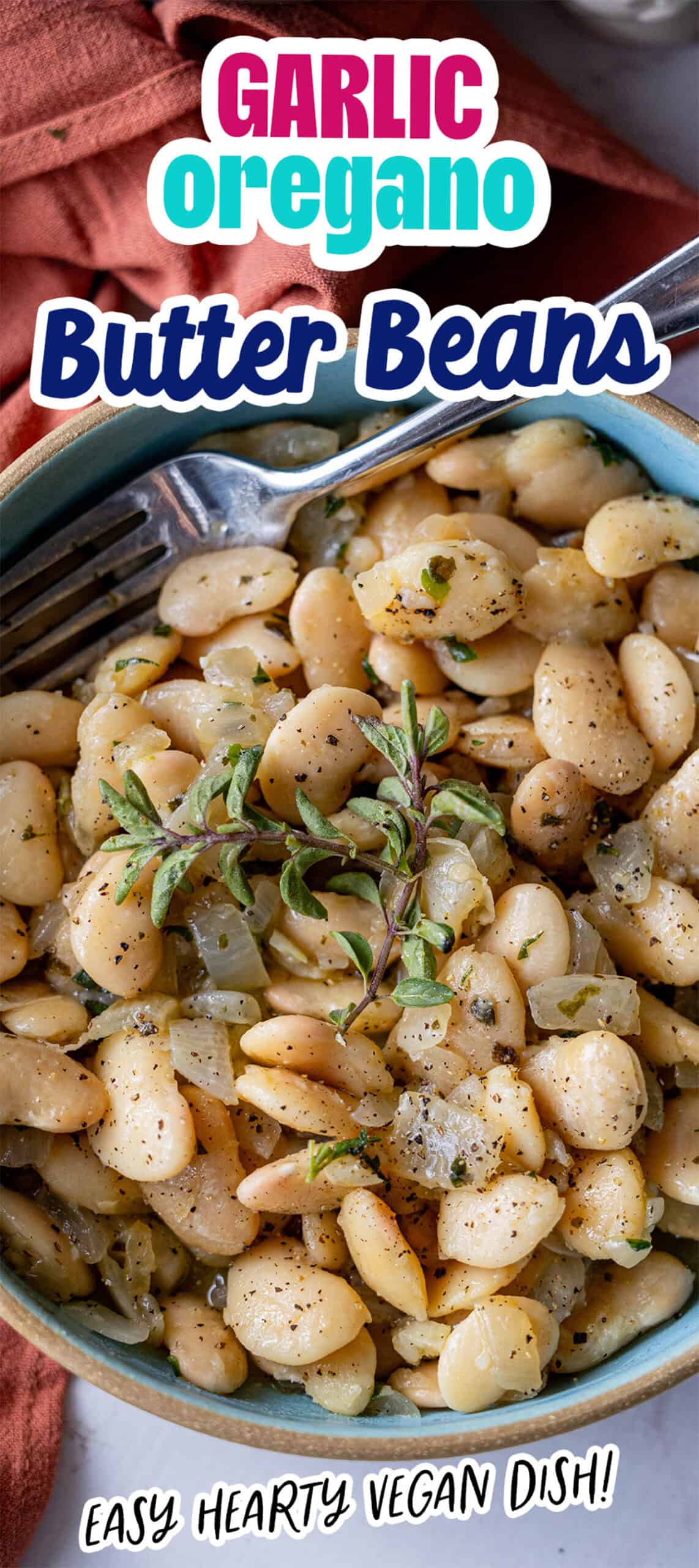 A bowl of garlic oregano butter beans topped with fresh herbs, alongside a fork. Text reads "Garlic Oregano Butter Beans" and "Easy Hearty Vegan Dish!.