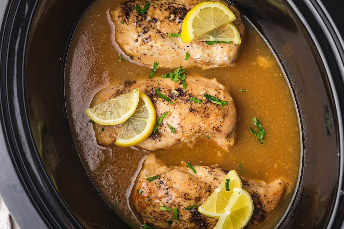 Savor the flavors of our Lemonade Chicken: tender, slow-cooked chicken breasts infused with lemon slices and garnished with fresh herbs, all simmered in a savory broth.