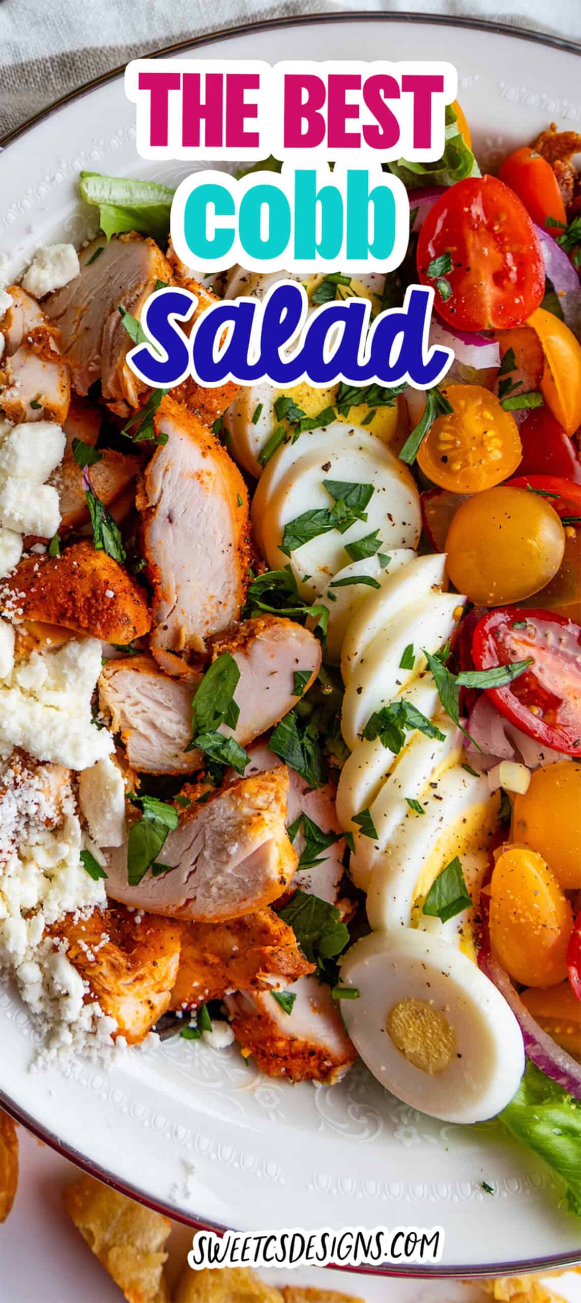 A plate of the best Cobb salad with sliced grilled chicken, hard-boiled eggs, cherry tomatoes, lettuce, and crumbled cheese, topped with chopped herbs. Text overlay reads "The Best Cobb Salad.
