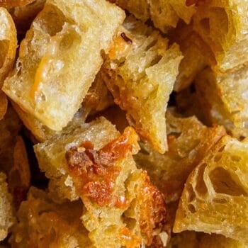 Close-up view of several pieces of bread with melted cheese, showing a crispy, golden-brown texture—perfect for making homemade croutons.