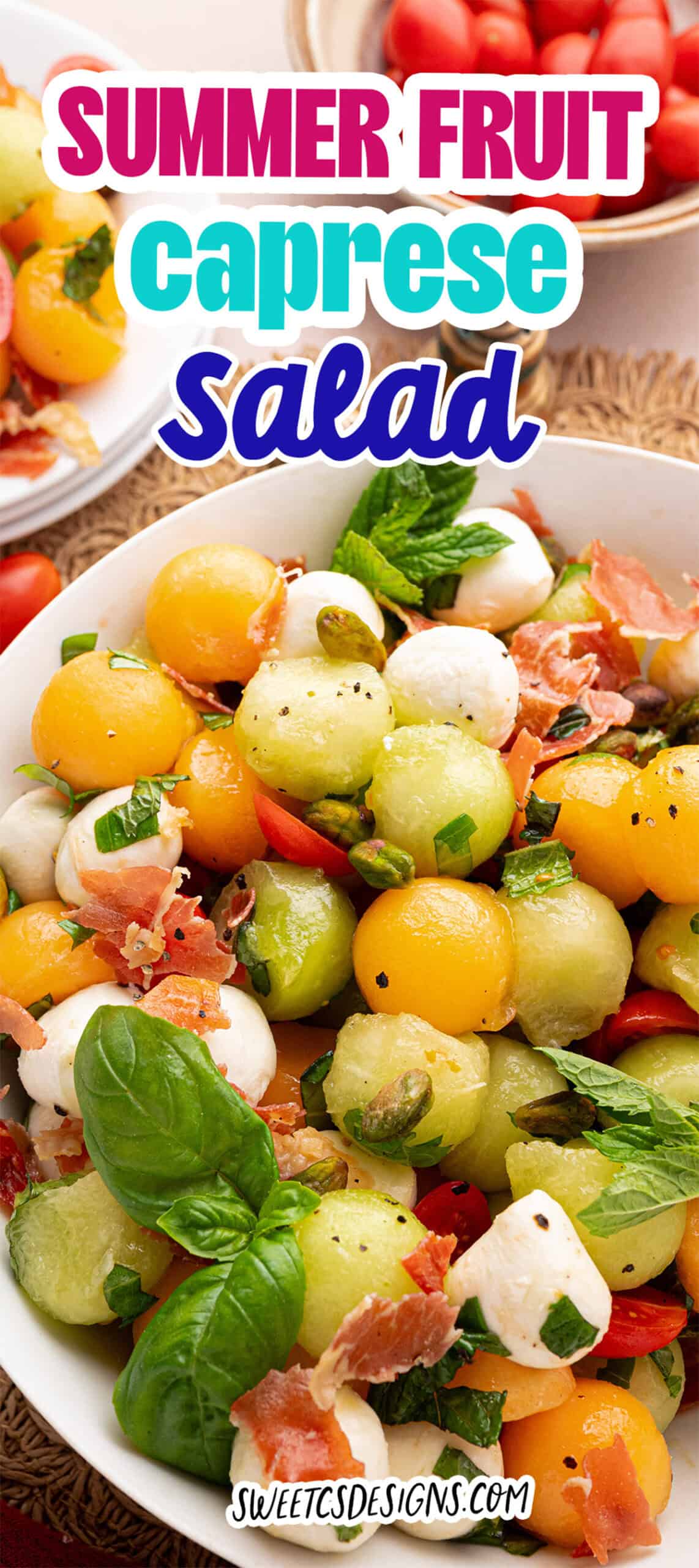 A bowl of Summer Fruit Caprese Salad with melon balls, mozzarella, basil, prosciutto, and grape tomatoes, garnished with fresh herbs.