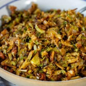 A close-up of a bowl filled with sautéed shredded Brussels sprouts mixed with browned, crispy bits—a perfect Brussels Sprouts Hash recipe for a flavorful side dish.