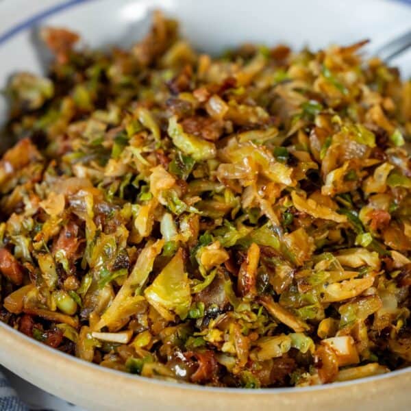 A close-up of a bowl filled with Brussels Sprouts Hash, featuring sautéed and shredded Brussels sprouts mixed with browned, crispy bits.