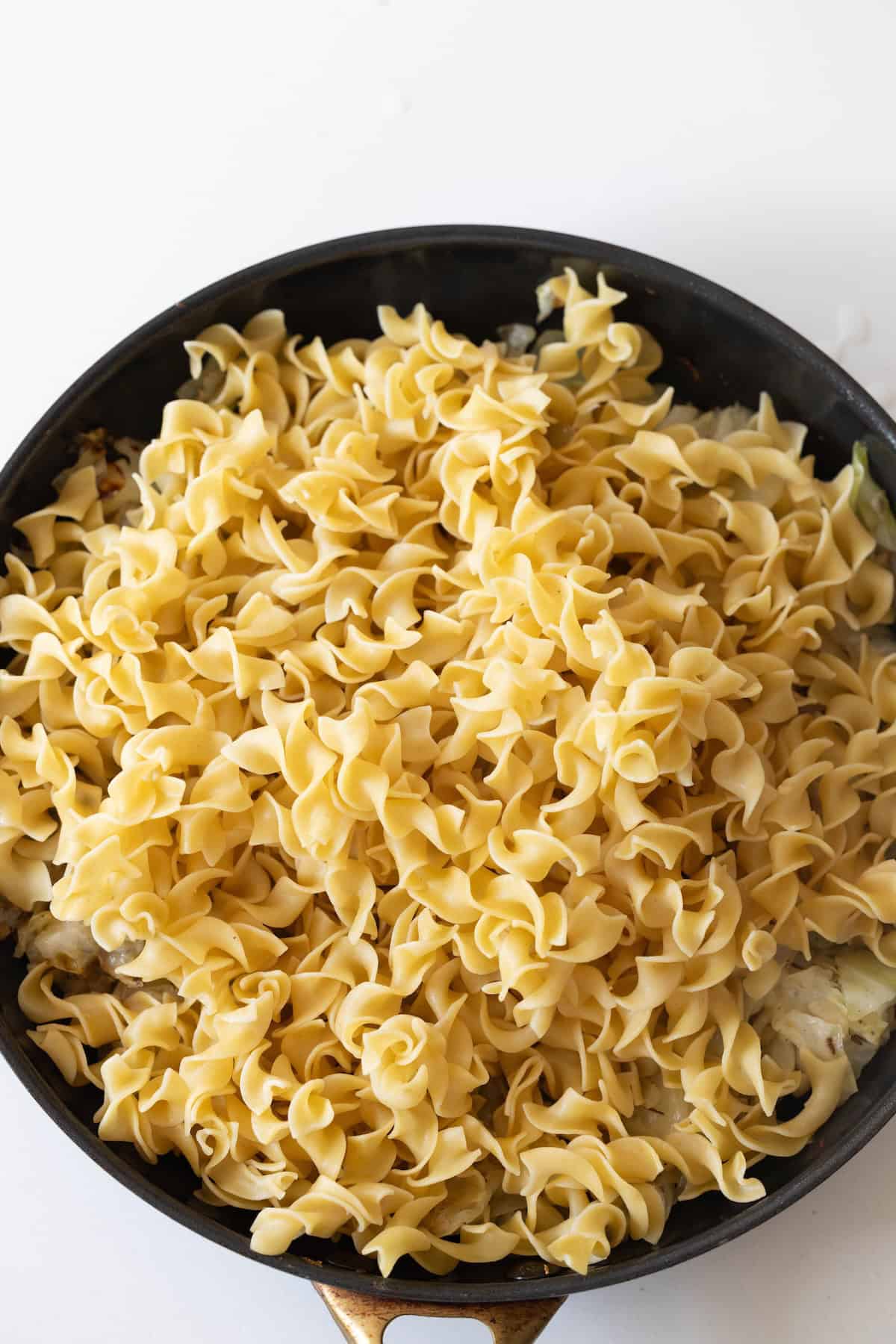 A bowl of noodles tossed with tender cabbage makes for a comforting and satisfying meal.