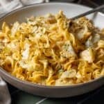 A bowl of cooked egg noodles tossed with sautéed cabbage and garnished with fresh chopped herbs creates a classic cabbage and noodles dish.