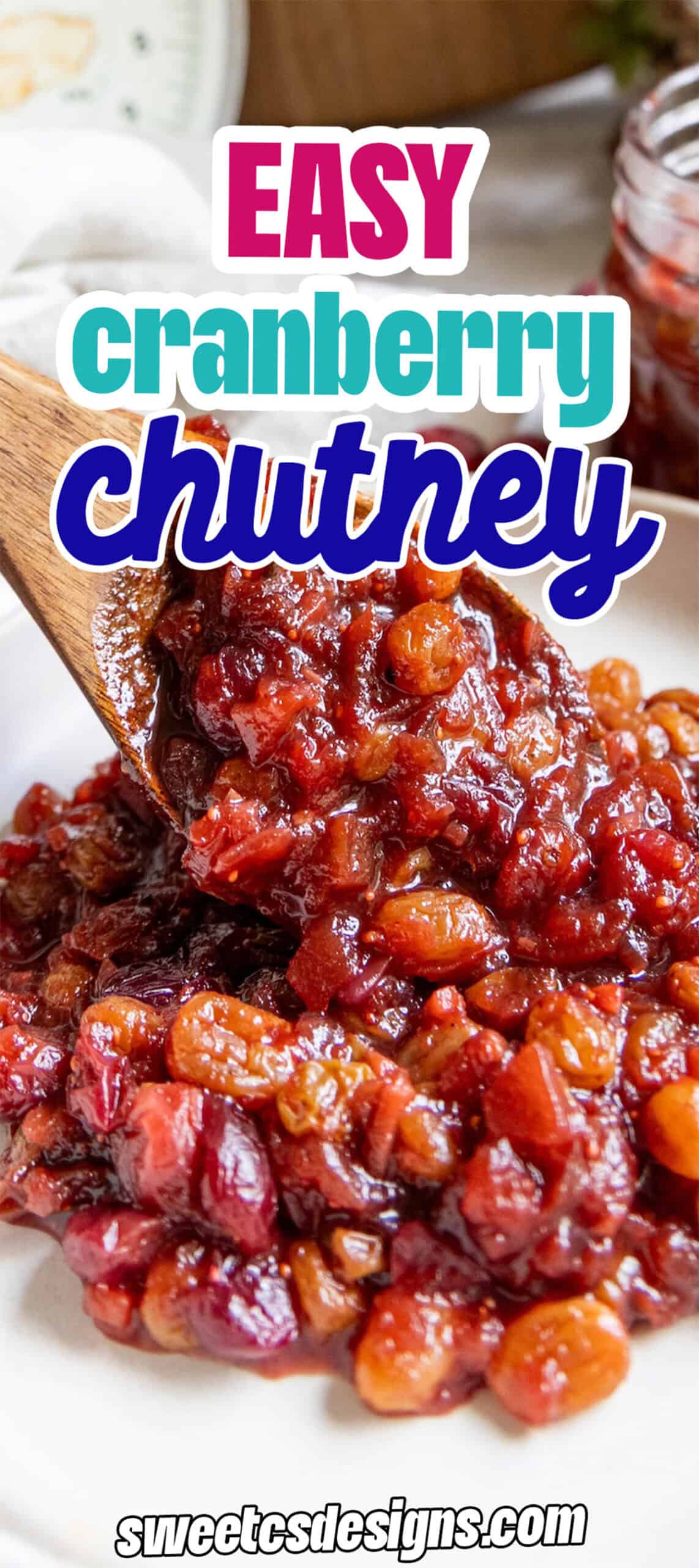 A wooden spoon scoops chunky cranberry chutney, filled with whole cranberries and raisins, onto a white plate.
