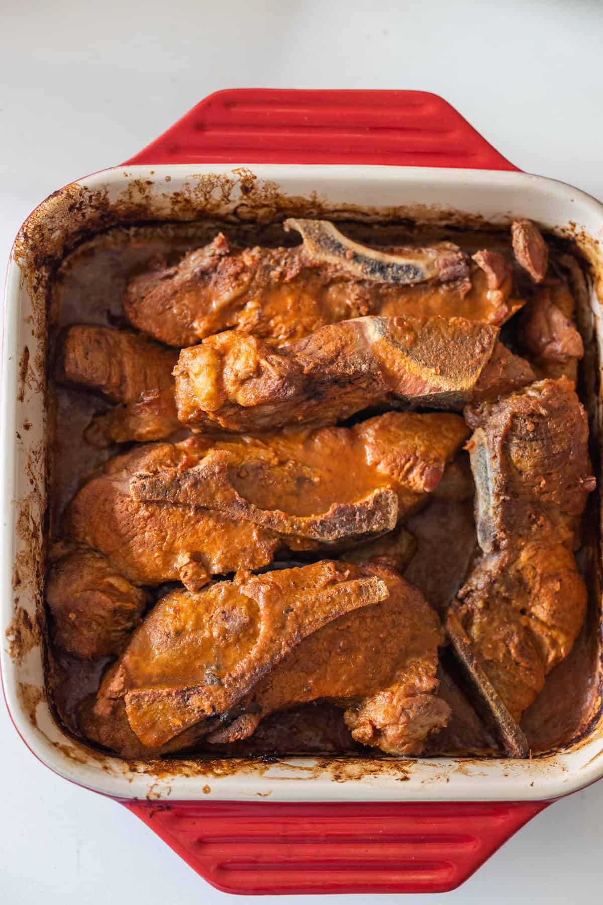 A dish of Country Style Ribs in a red and white pan.