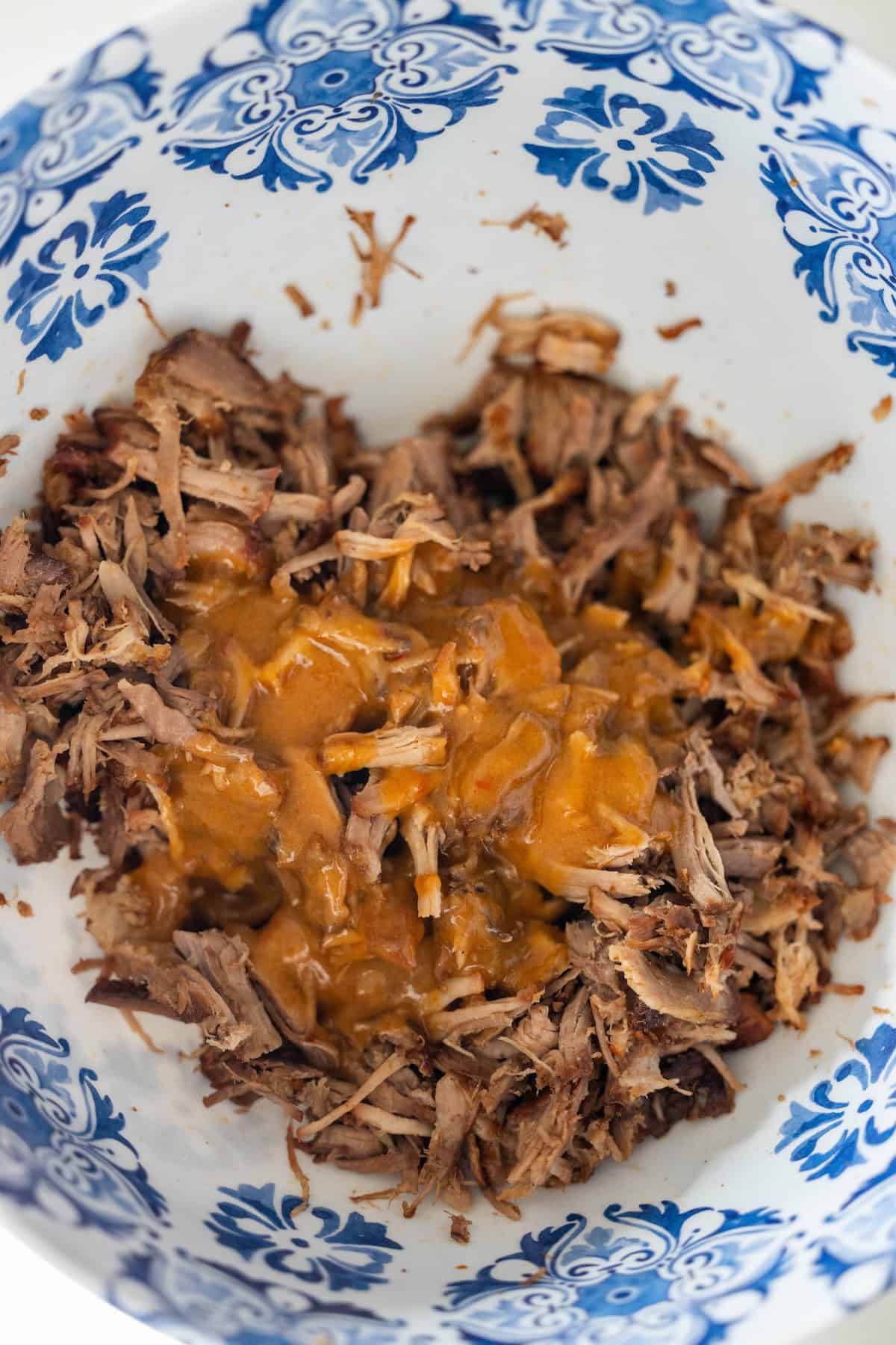 Shredded Country Style Ribs topped with brown sauce in a white bowl with blue decorative patterns.