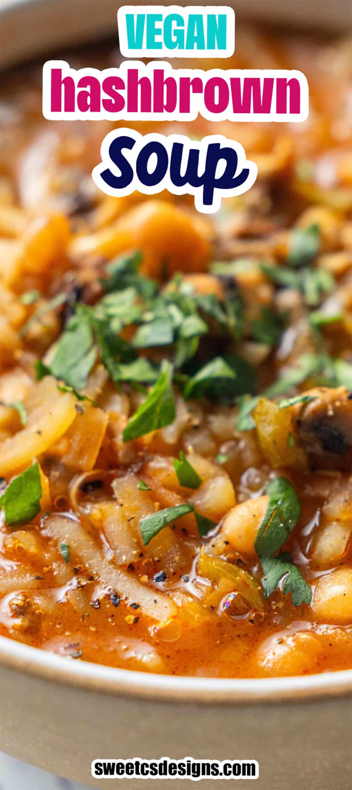 Close-up of Vegan Hashbrown Soup topped with fresh chopped herbs, featuring visible potatoes, beans, and vegetables in a tomato-based broth.