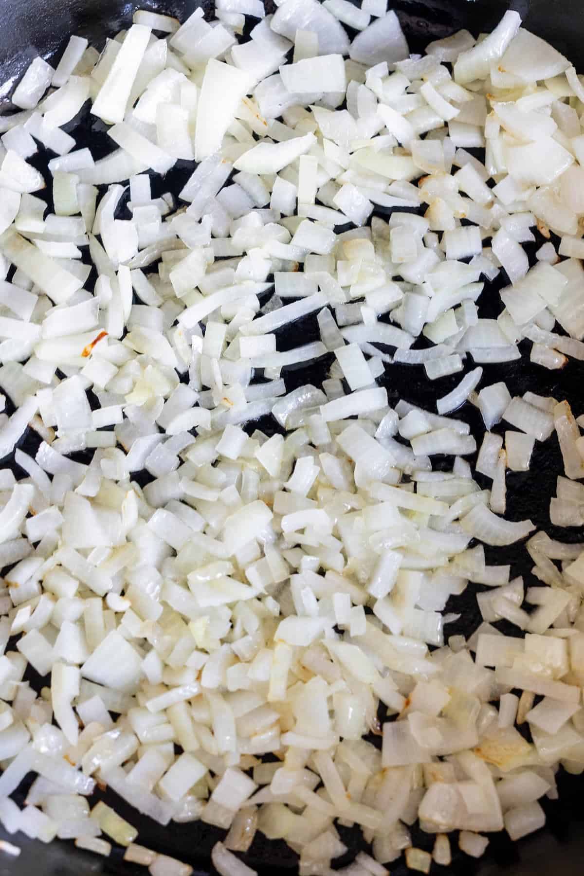 Chopped onions cooking in a skillet, beginning to soften and turn translucent—perfect for starting a classic Chopped Cheese Sandwich Recipe.