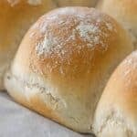 Close-up of freshly baked Scottish Morning Rolls with a light dusting of flour on top, arranged closely together.