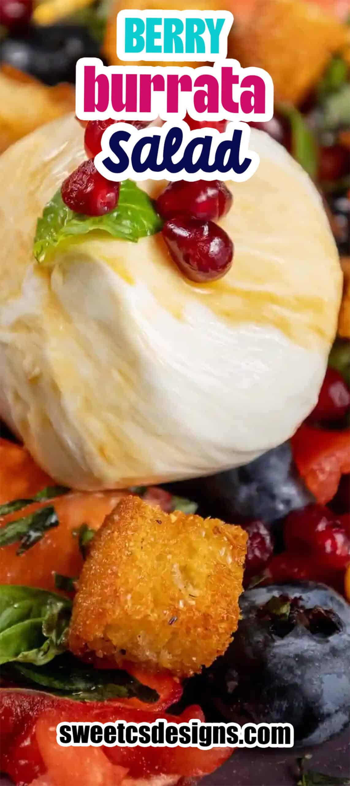 Close-up of a berry burrata salad featuring a ball of burrata cheese, pomegranate seeds, croutons, blueberries, greens, and a mint leaf for a fresh and vibrant berry fruit salad with burrata.